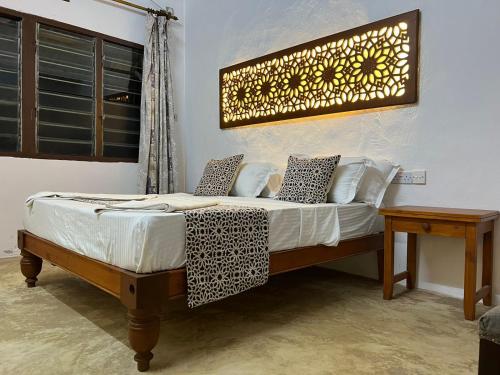 a bedroom with a bed with a light on the wall at Beytsalaam Apartments in Lamu