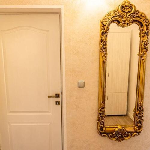 a gold mirror on a wall next to a door at Grand Hotel Baroc in Zalău