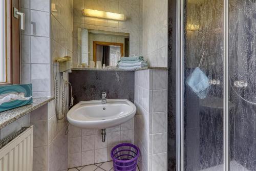 a small bathroom with a sink and a shower at Kurpension Freudenstein in Bad Füssing