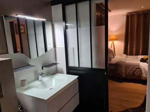 a bathroom with a sink and a mirror and a bed at A Sulana Chambre d'hôtes in Valle-di-Campoloro
