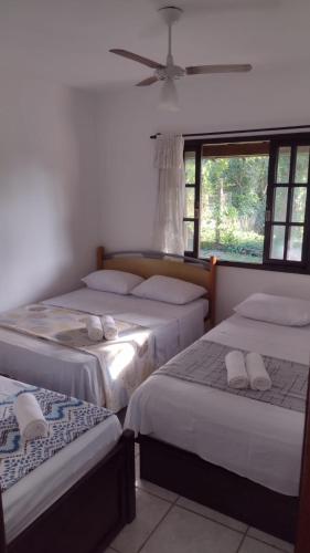 a room with three beds and a window at PENEDO COM 4 QUARTOS, PISCINA E SAUNA. 600M do CENTRO in Penedo