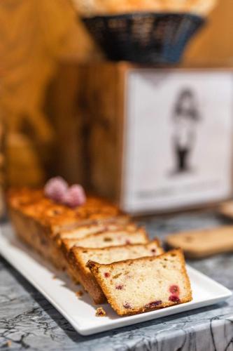 a white plate with a piece of bread on a table at Garlande Hôtel Avignon Centre in Avignon