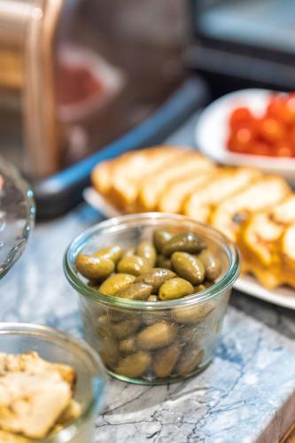 a bowl of olives and bread on a table at Garlande Hôtel Avignon Centre in Avignon