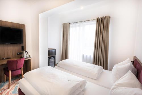 a hotel room with two beds and a window at Firzlaff's Hotel in Neumünster