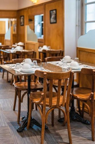 a dining room with wooden tables and chairs at Garlande Hôtel Avignon Centre in Avignon