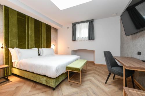 a hotel room with a bed and a desk at Palazzo Santo Spirito in Bergamo