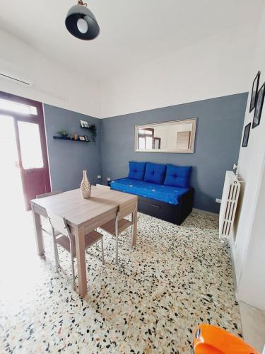 een woonkamer met een blauwe bank en een tafel bij La Casa del Borgo in Lecce