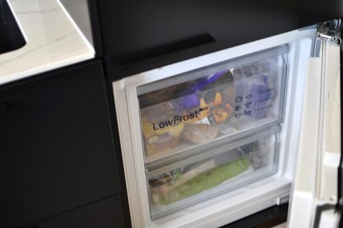 um frigorífico aberto com comida dentro em One-bedroom apartment in the center of Saariselkä em Saariselka