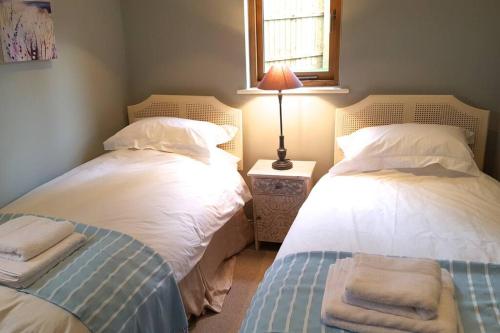 Un pat sau paturi într-o cameră la River Cottage - Stunning estuary views