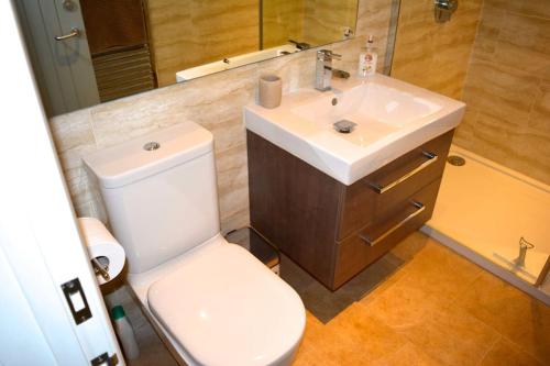 een badkamer met een wit toilet en een wastafel bij River Cottage - Stunning estuary views in Aldeburgh