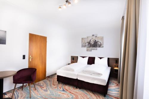 a hotel room with a bed and a table at Firzlaff's Hotel in Neumünster