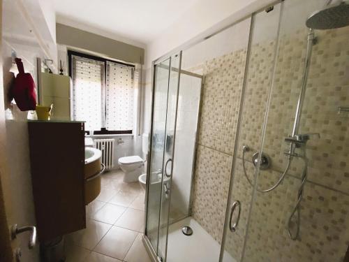 y baño con ducha de cristal y aseo. en Appartamento Bellavista - Fronte Lago di Varese en Gavirate
