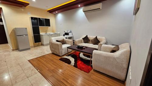 a living room with two couches and a table at رؤوم إن للشقق الفندقية-Raoum Inn Hotel Apartments-Buraydah in Buraydah