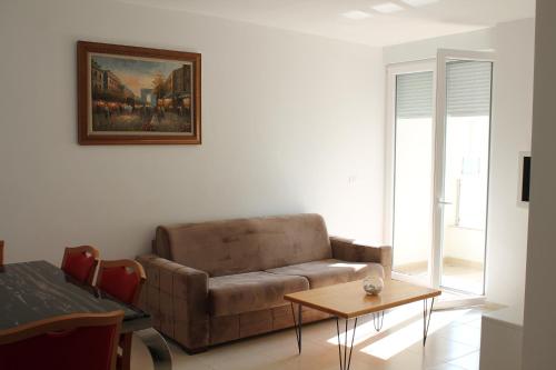 a living room with a couch and a table at Blue Apartments & Hotel Shengjin in Shëngjin