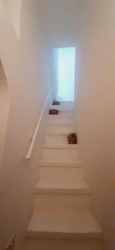 a stairway with white walls and white stairs at Dimora Lavinia Casa vacanze Centro storico Ostuni in Ostuni