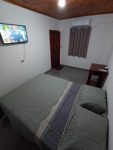 1 dormitorio con 1 cama y TV en la pared en Igr. Planta Baja en Puerto Iguazú