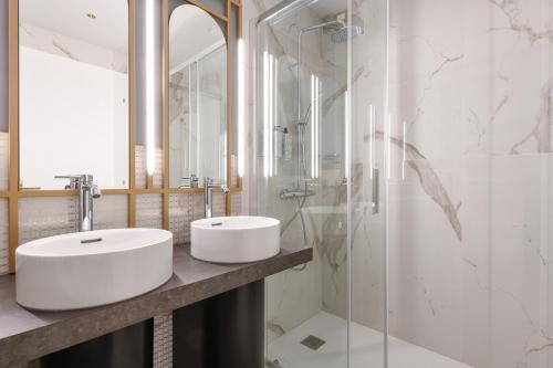 a bathroom with two sinks and a glass shower at Palazzo Santo Spirito in Bergamo