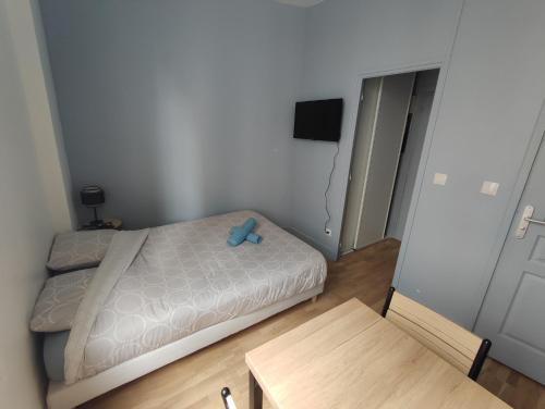 a small bedroom with a bed with a blue stuffed animal on it at Studio cosy - Hypercentre - 20 min to Paris in Maisons-Laffitte