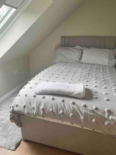ein Bett mit einer weißen Bettdecke in einem Schlafzimmer in der Unterkunft Mid Antrim Modern Apartment in New Ferry