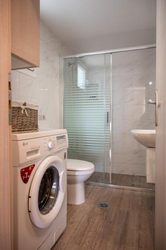 a washing machine in a bathroom with a toilet at Konstantina's Luxury Apartment in Nafplio