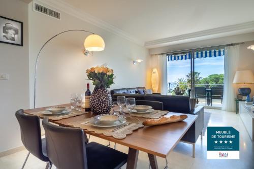 une salle à manger avec une table et des chaises en bois dans l'établissement Cannes Croisette Superbe 3P front de mer, à Cannes