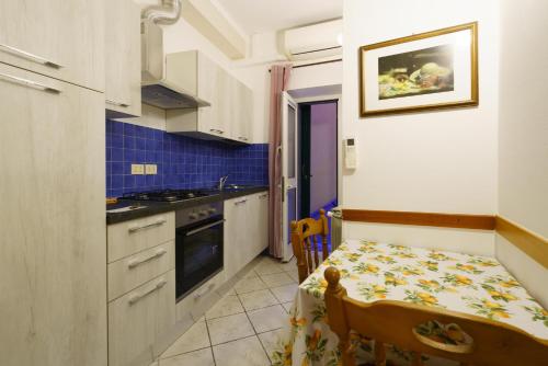 a kitchen with a table and a small kitchen with a table and a small table at A due passi dal Mare in Riomaggiore