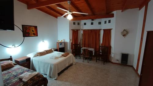 a bedroom with two beds and a table and a ceiling at Castelar - Hotel & Apart in Huerta Grande