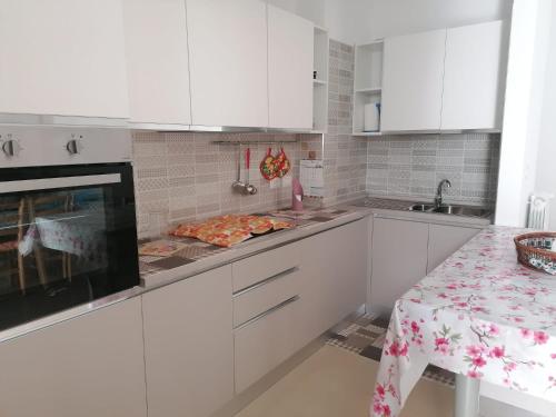 a white kitchen with white cabinets and a table at Albachiara in Galatina