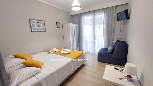 een kleine slaapkamer met een bed en een stoel bij Vasileiadou Coastal Rooms in Flogita