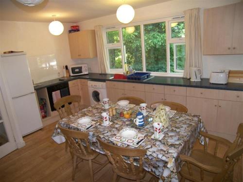 a kitchen with a table with chairs and a tableclotholitics at Glenauld Cottage in Kirkcudbright