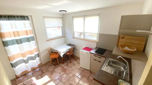 a small kitchen with a sink and a table at Haus Mairösl in Silandro