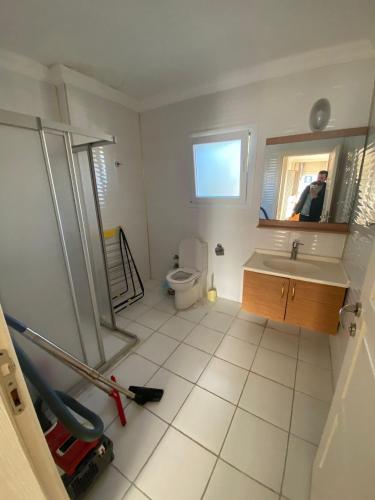 a bathroom with a sink and a toilet and a mirror at Kuşadası kadınlar denizi (BİDRi İNŞAAT) in Kuşadası