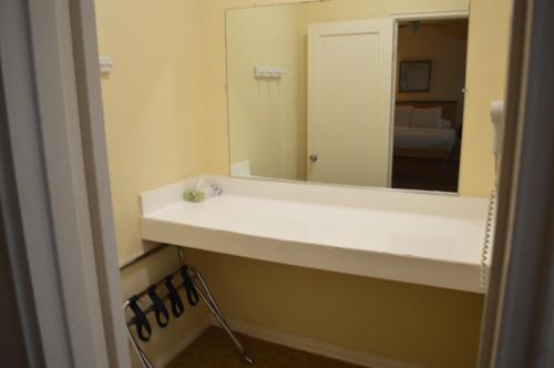 y baño con lavabo blanco y espejo. en Island House South Beach, en Miami Beach