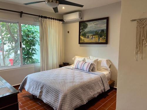 - une chambre avec un lit et un ventilateur de plafond dans l'établissement The Mermaid and The Pearl Boutique B&B, à Isla Mujeres