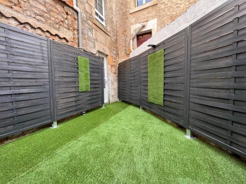 a courtyard with black fences and green grass at LA PALMERAIE -wifi fibre- centre ville -PROPERTY RENTAL NM in Fontenay-le-Comte