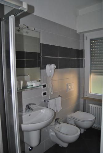 a bathroom with two sinks and a toilet at Hotel Casa Gagliardi in Brenzone sul Garda