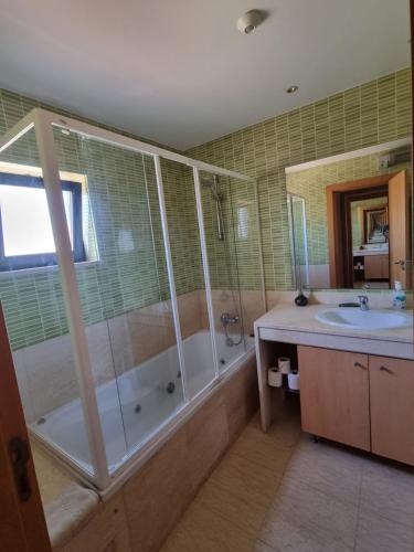 ein Badezimmer mit einer Dusche, einer Badewanne und einem Waschbecken in der Unterkunft Luxury city Villa Olivia 10 - 15 min to the Beach Oura, private swimming pool in Albufeira