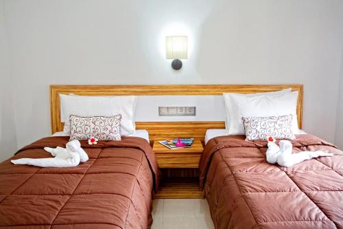 Postel nebo postele na pokoji v ubytování Tanjung Sari Inn