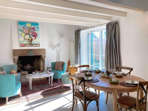 a living room with a table and chairs and a fireplace at KER MAJA : Charmante Maison 1930 * Jardin * 2 vélos * WIFI in Carnac
