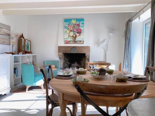 a dining room with a table and a fireplace at KER MAJA : Charmante Maison 1930 * Jardin * 2 vélos * WIFI in Carnac