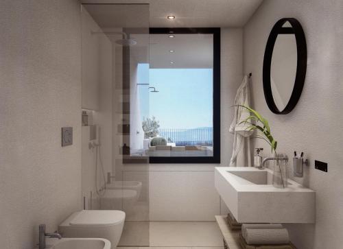 a bathroom with a sink and a toilet and a mirror at Seaview House Cala Gonone in Cala Gonone