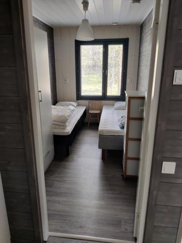 a room with two beds and a window at Lapponia Äkäslompolo in Äkäslompolo