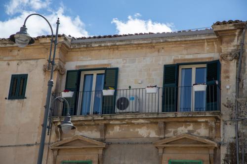 a building with green shuttered windows and a street light at Casa Vacanza da Dina in Modica