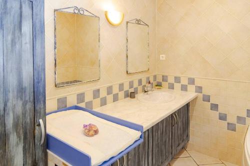 La salle de bains est pourvue d'un lavabo et d'un miroir. dans l'établissement Gîte Puydepont, à Neuvic