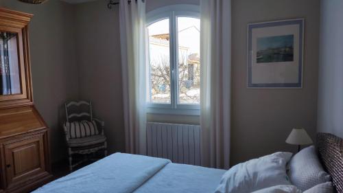 une chambre avec un lit, une fenêtre et une chaise dans l'établissement Chambre et petit déjeuner, à Sérignan-du-Comtat