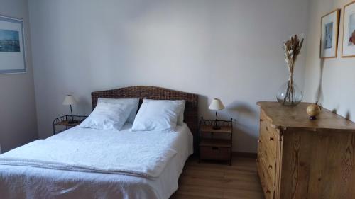 une chambre avec un lit avec des draps blancs et des oreillers dans l'établissement Chambre et petit déjeuner, à Sérignan-du-Comtat