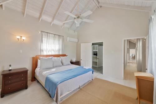 a bedroom with a bed and a ceiling fan at Hullabaloo in Saint James