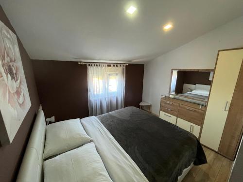 a bedroom with a bed and a dresser and a mirror at Apartments Mira in Bibinje