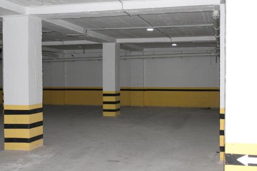 an empty parking garage with yellow and black columns at Blue Apartments & Hotel Shengjin in Shëngjin