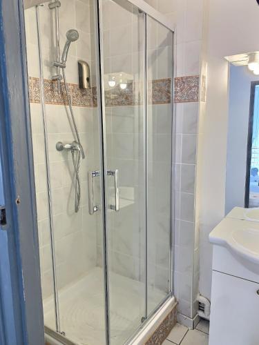 une douche avec une porte vitrée dans une salle de bain dans l'établissement Quartier historique et populaire du château de Pau, à Pau